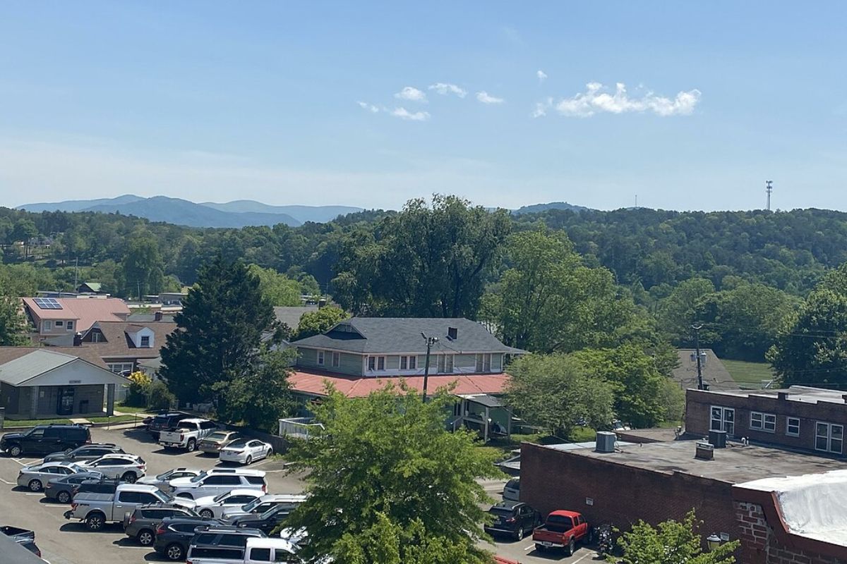 a parking lot with cars and trees in the background